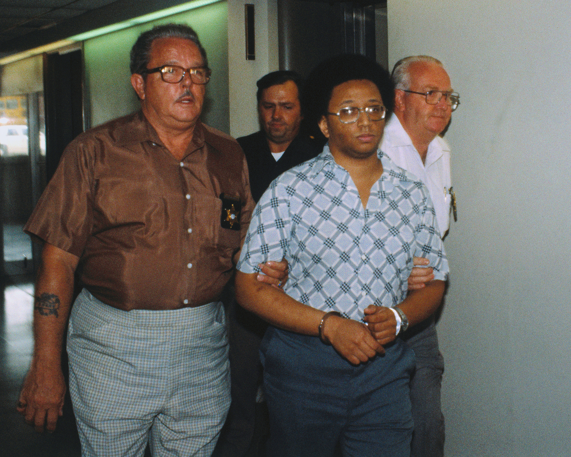 Men Leading Wayne Williams in Handcuffs